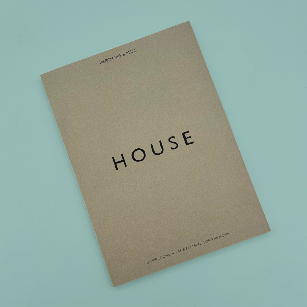 A grey book with 'HOUSE' in black font, on a blue background.