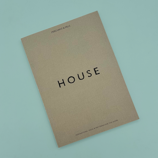 A grey book with 'HOUSE' in black font, on a blue background.