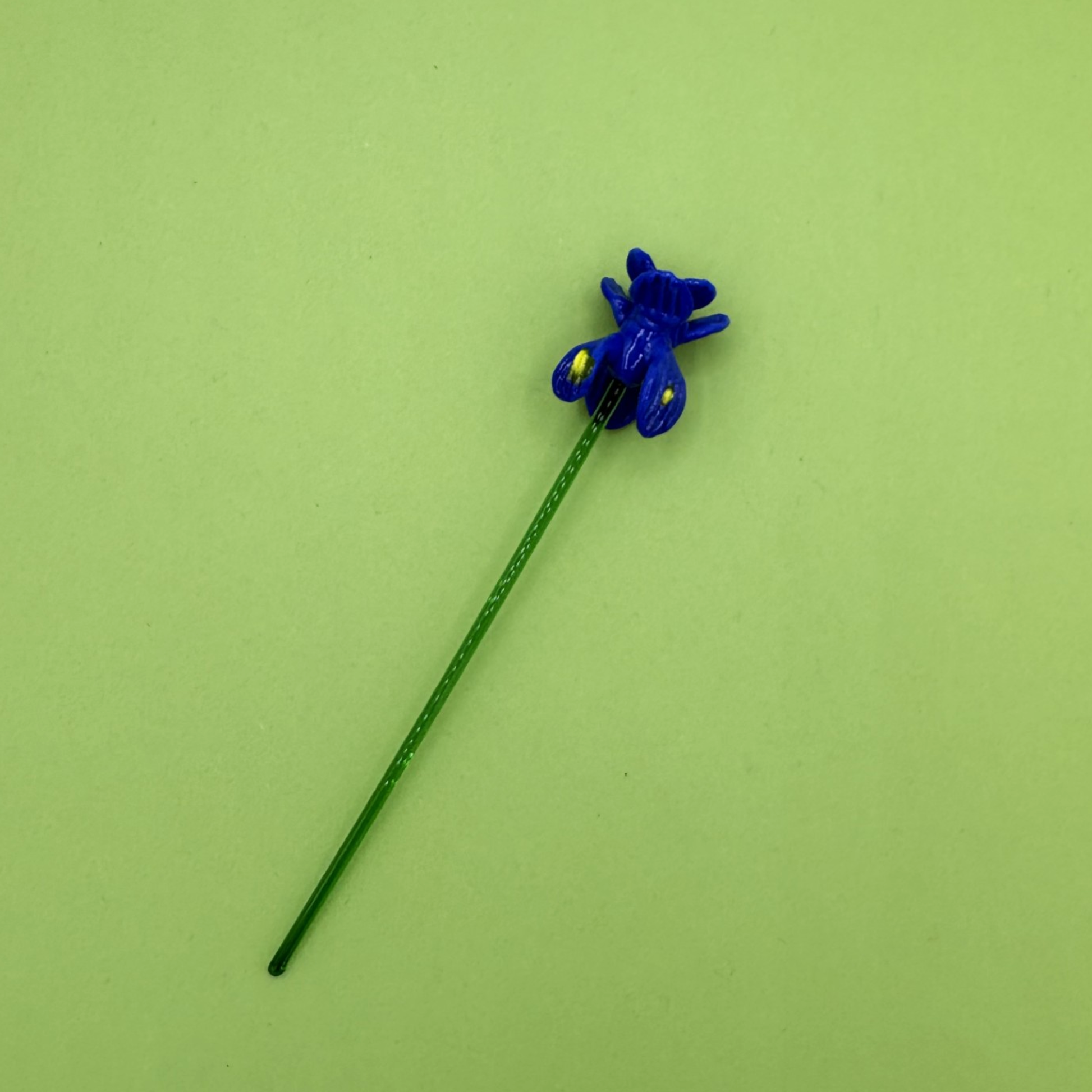 Blue glass flower with a green background
