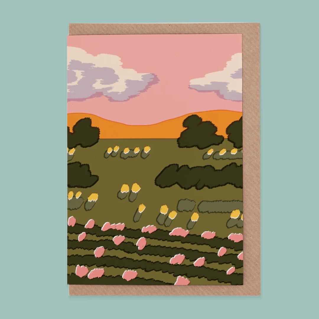 Greetings card of a landscape with trees, flowers, and a pink sky on a light blue background.
