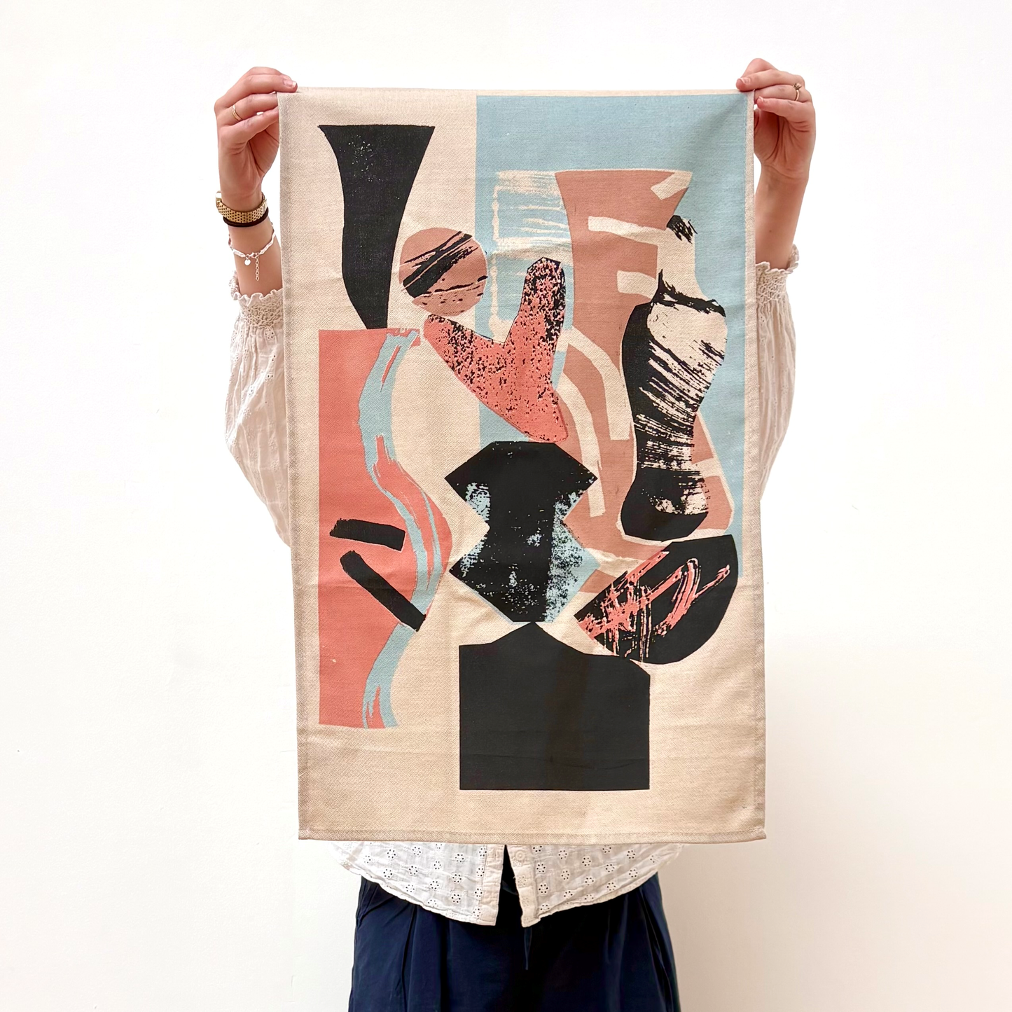 Person holding a decorative towel with abstract design on a white background