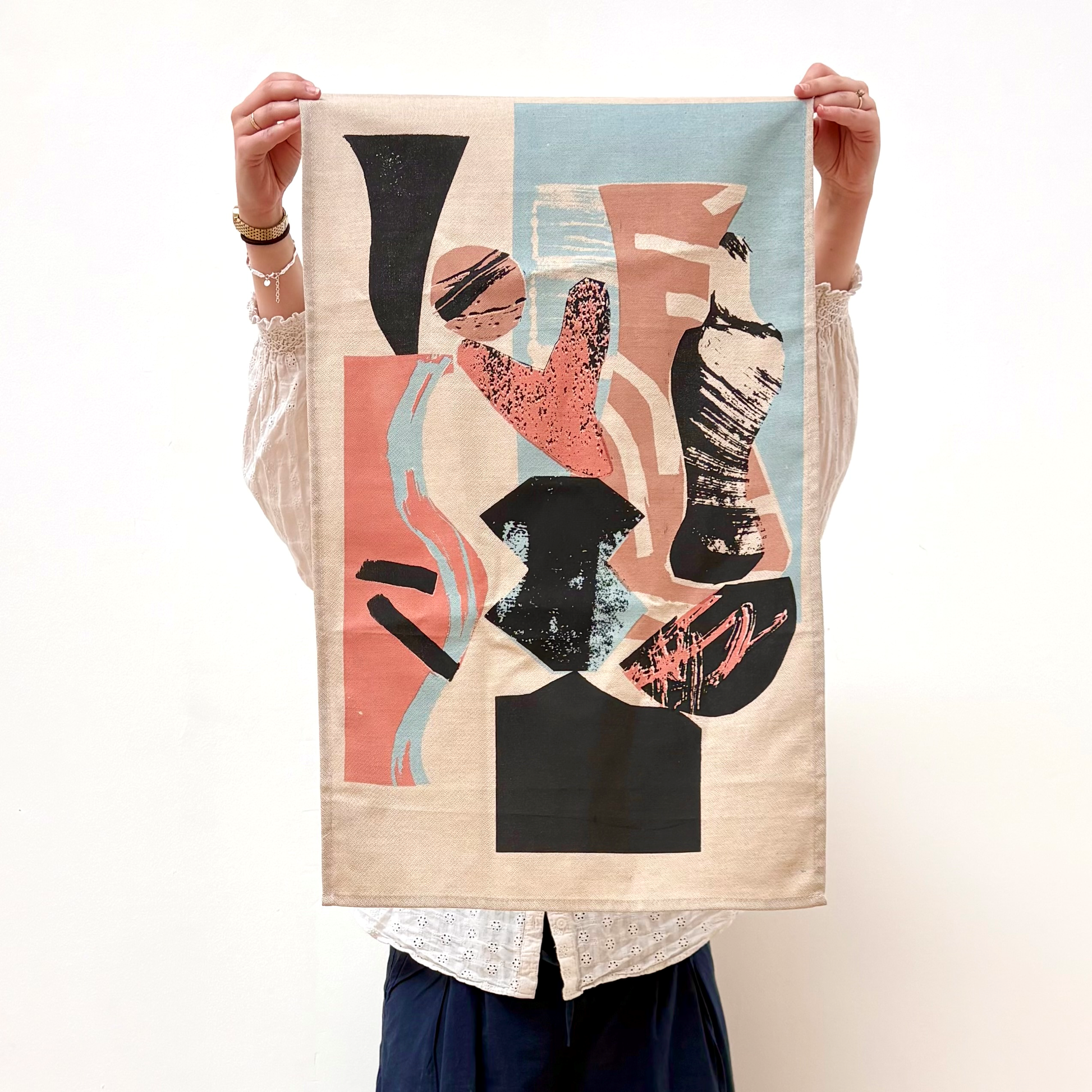 Person holding a decorative towel with abstract design on a white background