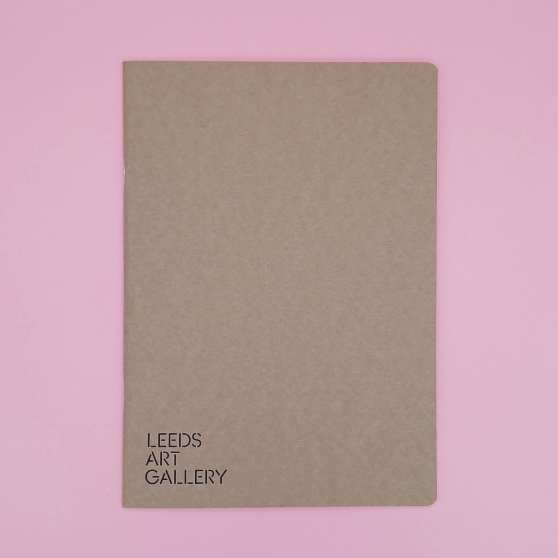 Brown notebook with 'Leeds Art Gallery' text on a pink background