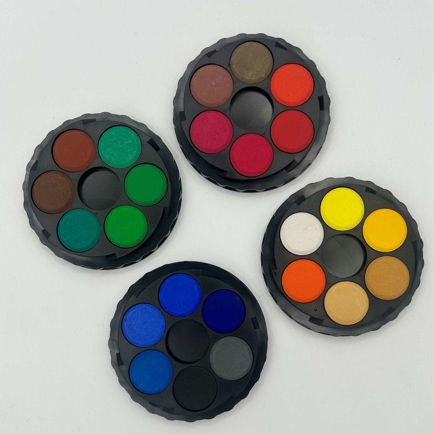 Four round color palettes with different sets of colors on a white background