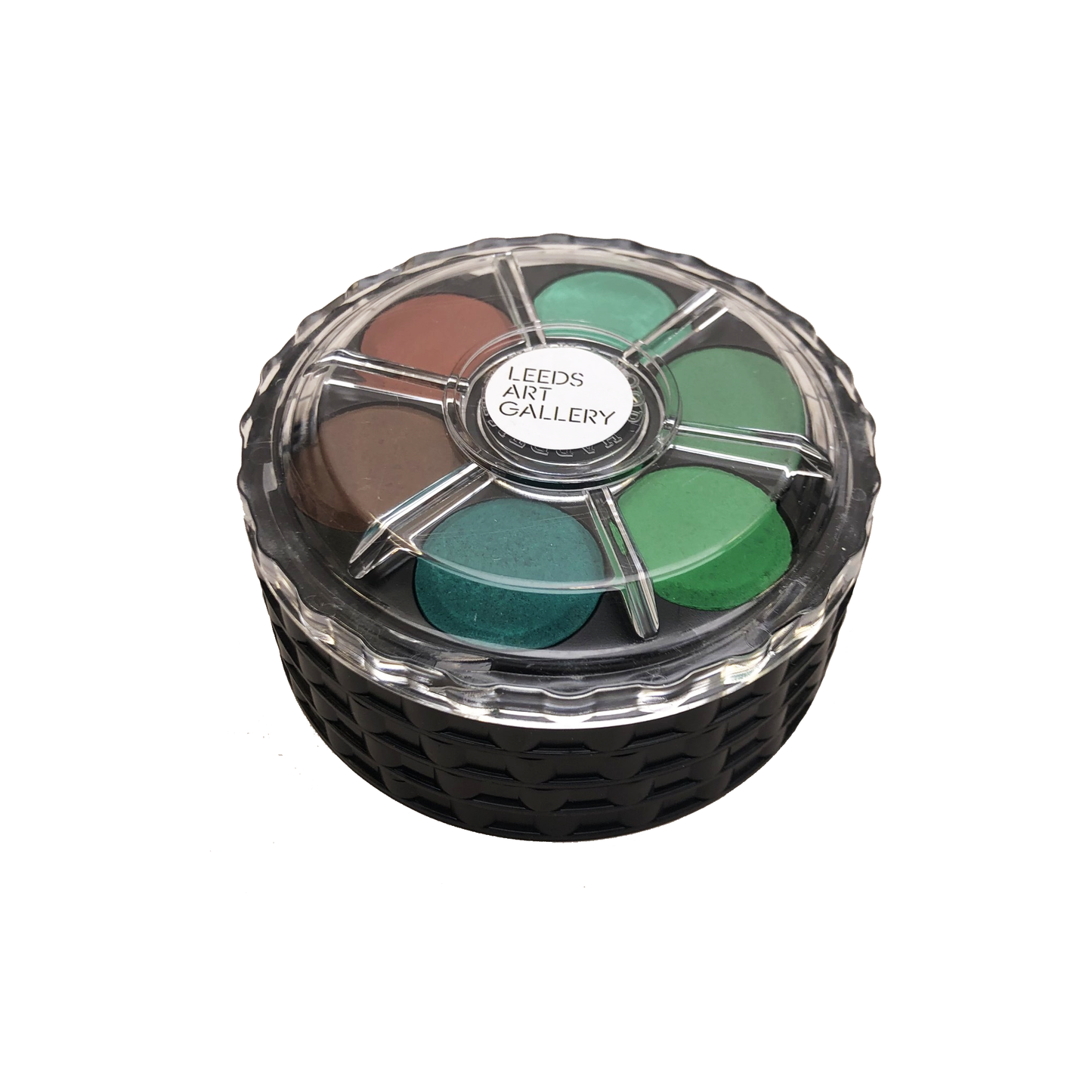 Watercolour palette with shades of green and brown in a clear container on a white background