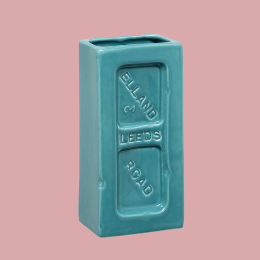 Turquoise rectangular ceramic vase with 'Elland & Leeds Road' text on a pink background