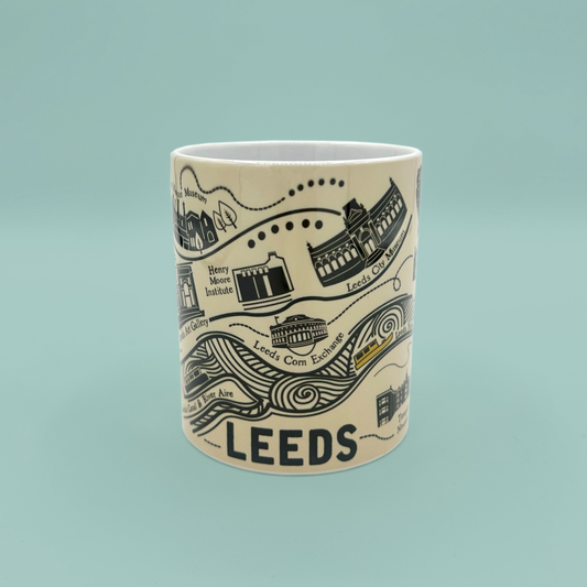 Ceramic mug with black illustrations and text on a light blue background