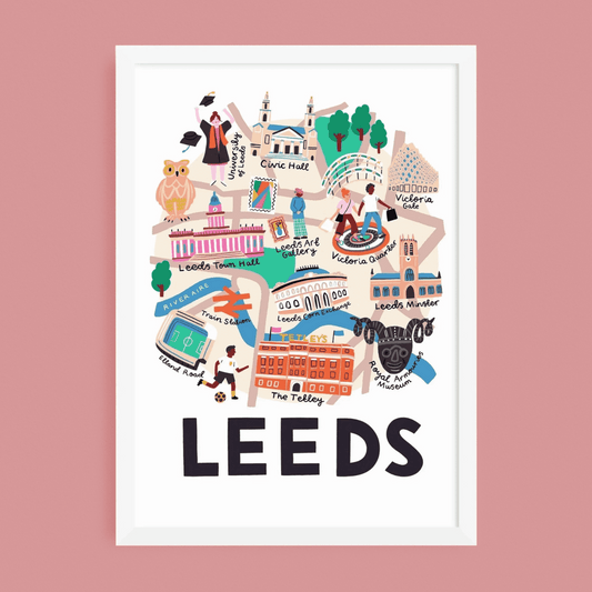 A framed art print featuring a colorful illustrated map of Leeds, with the word 'LEEDS' in large black letters at the bottom, shown against a solid pink background.