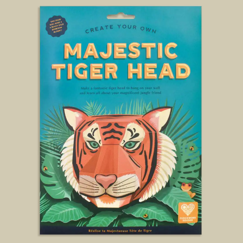 A flat-lay product shot of a cardboard craft kit package titled 'Majestic Tiger Head' with a colorful illustration of a tiger head surrounded by green leaves on a turquoise background.