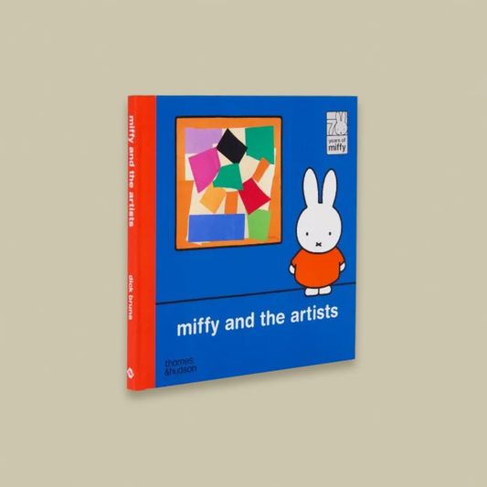 Book titled 'miffy and the artists' with a blue cover and red spine on a beige background