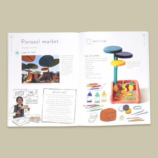 An open printed book spread titled 'Parasol market' on a plain beige background. The pages contain text, small illustrations, and a colourful drawing of a toy-like market setup with shelves, fruit, bottles, and accessories.