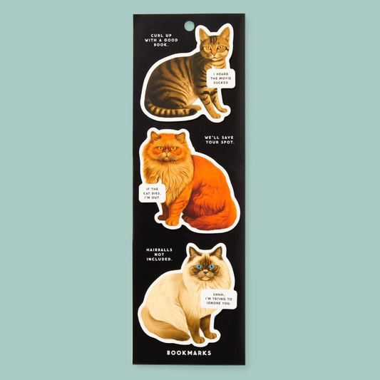A black rectangular magnet sheet featuring three illustrated cats with humourous text labels, shown on a light blue background. The sheet is labeled 'BOOKMARKS' at the bottom.