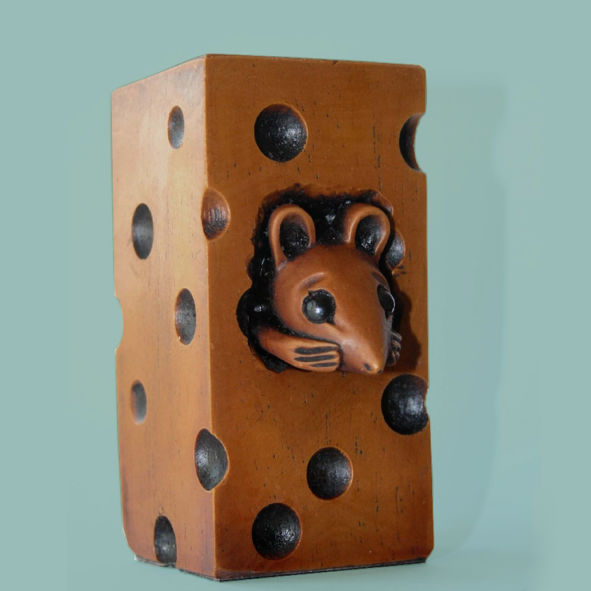 Carved figurine of a mouse inside a block of cheese.