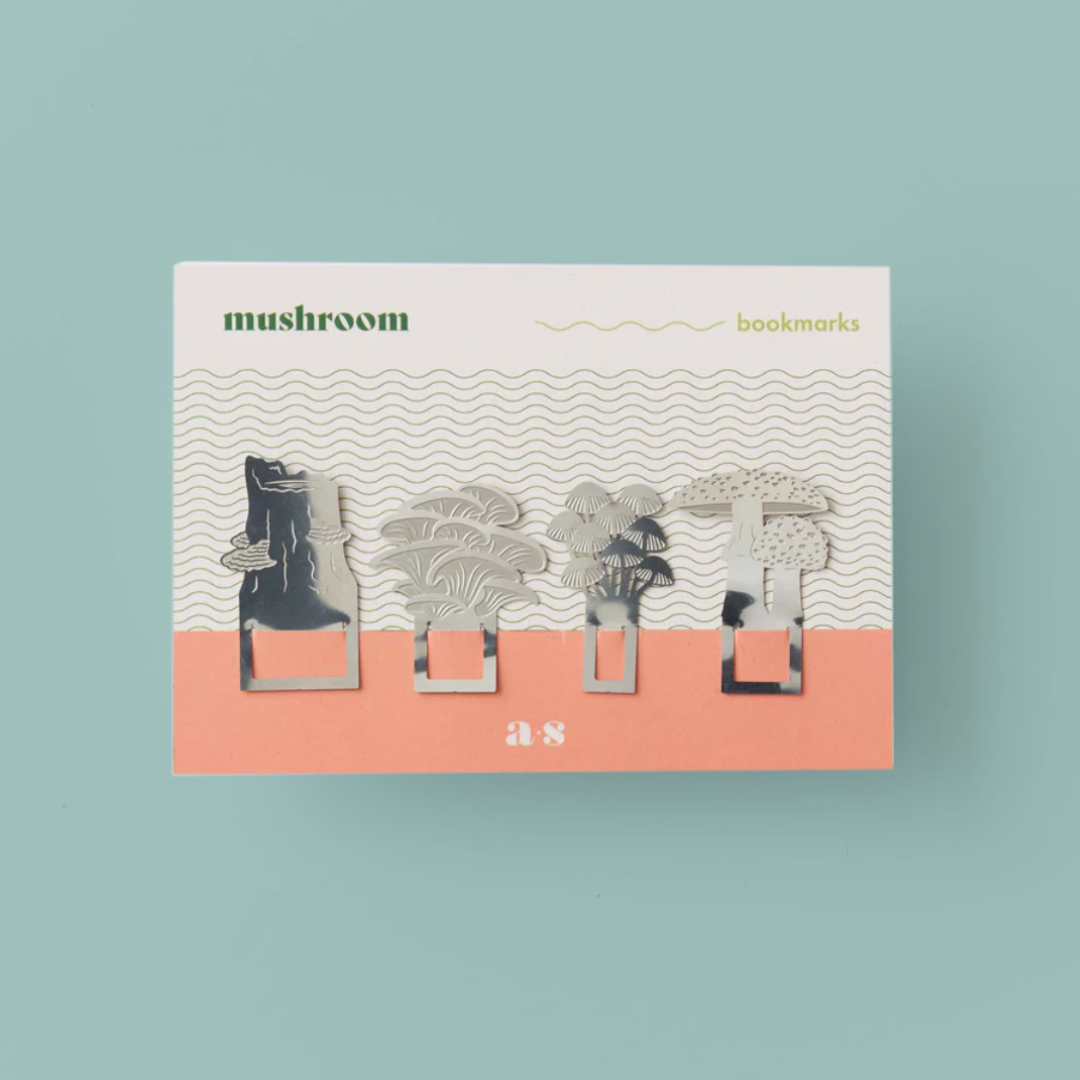 4 mushroom shaped steel bookmarks on a white and pink card.