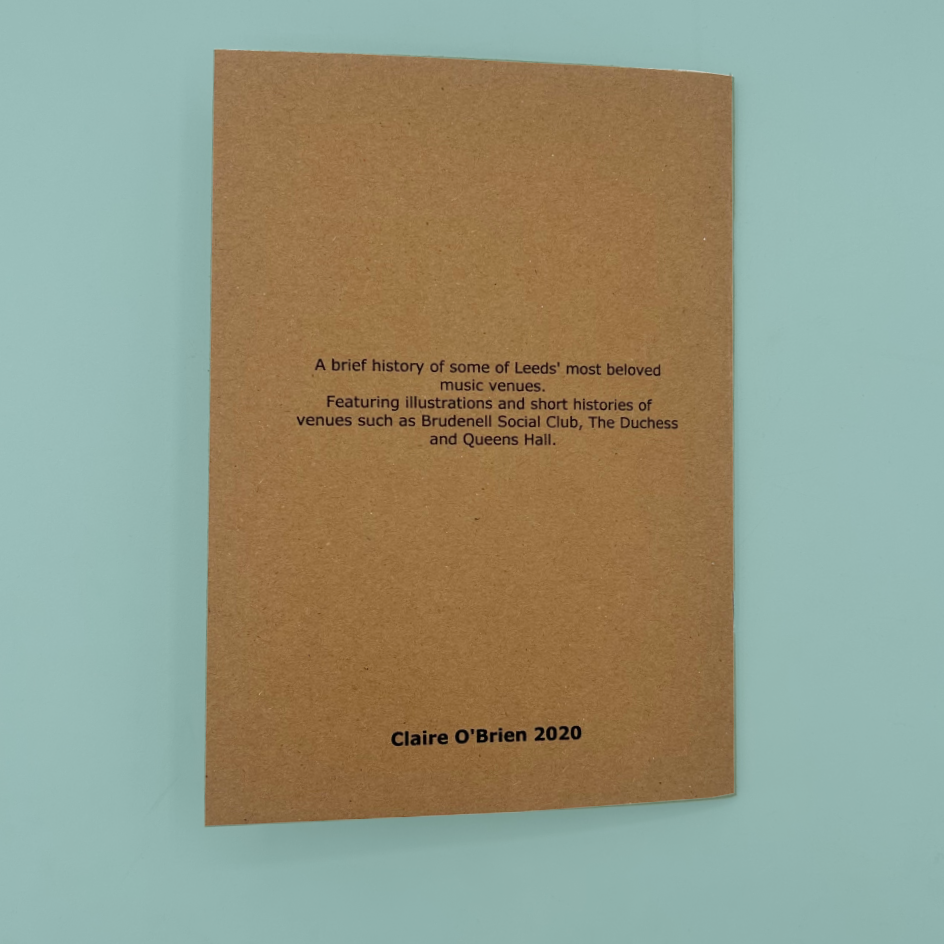 A  brown kraft paper zine cover with black printed text, photographed against a light blue background. The text reads: 'A brief history of some of Leeds' most beloved music venues.'