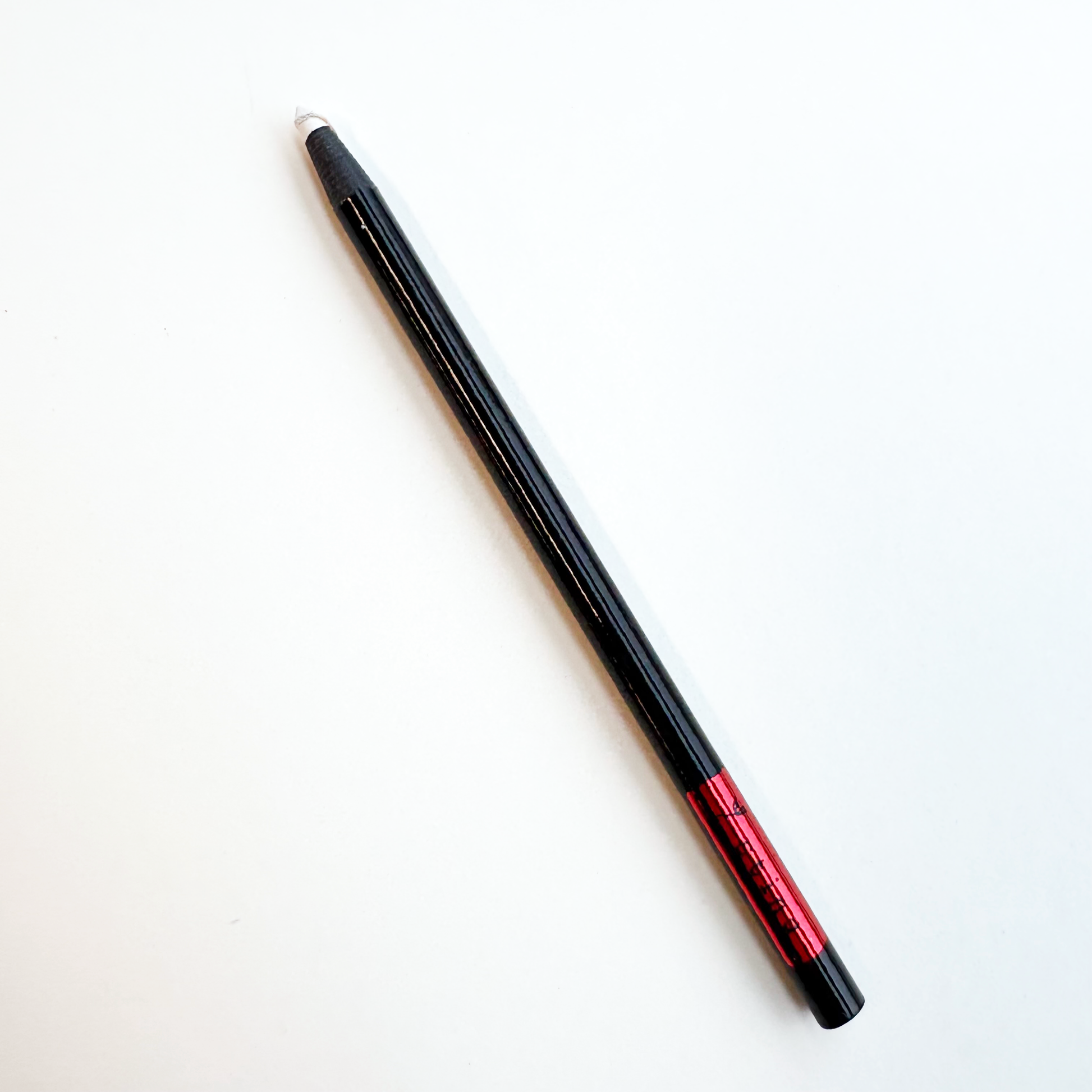 black pencil with white oil nip on a white background