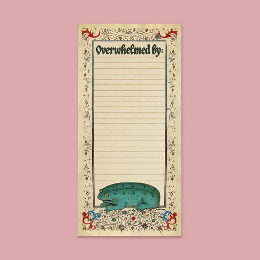 A vintage-style lined notepad with the heading 'Overwhelmed by:' and a decorative border featuring a teal frog at the bottom, shown centered on a dusty pink background.