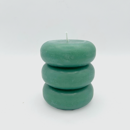 A blue pillar candle with a curvy shape.