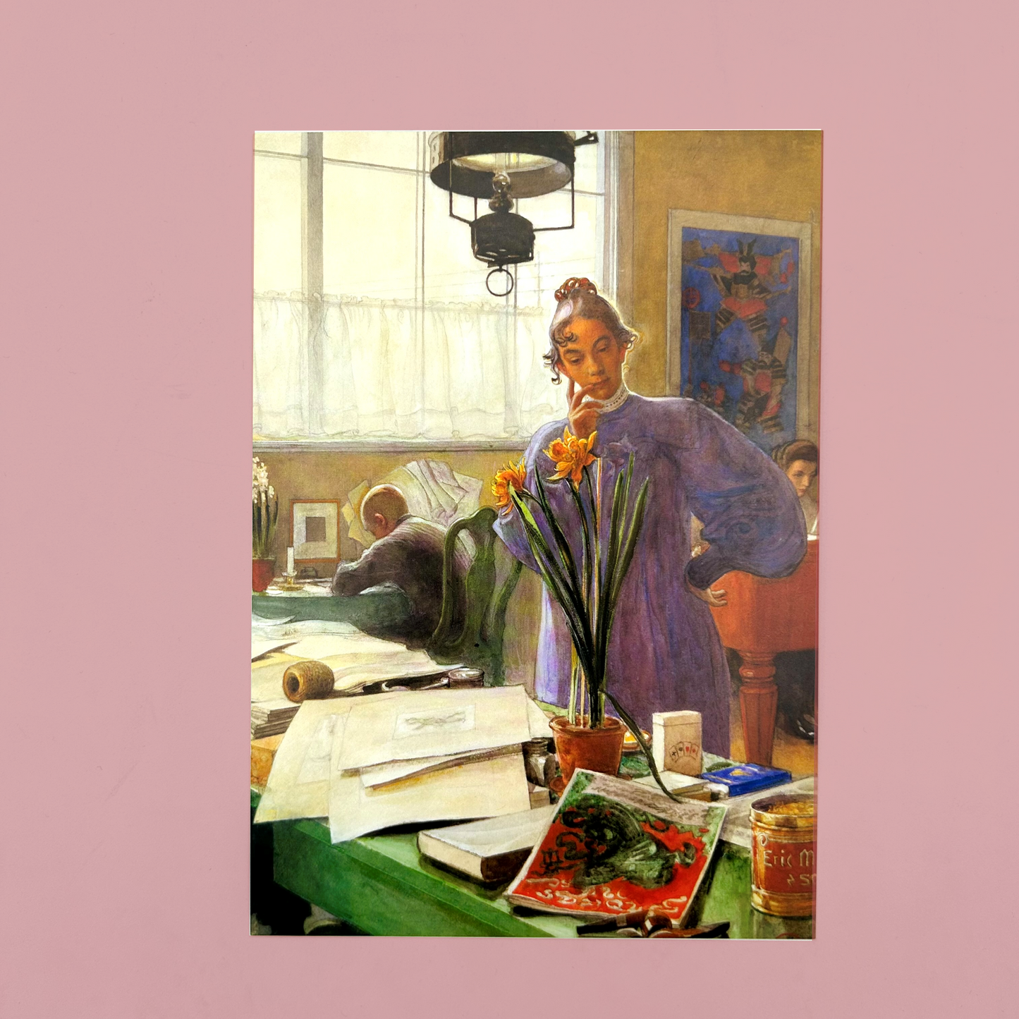 Postacrds of a painting of a woman in a room with a desk and various items, holding a flower.