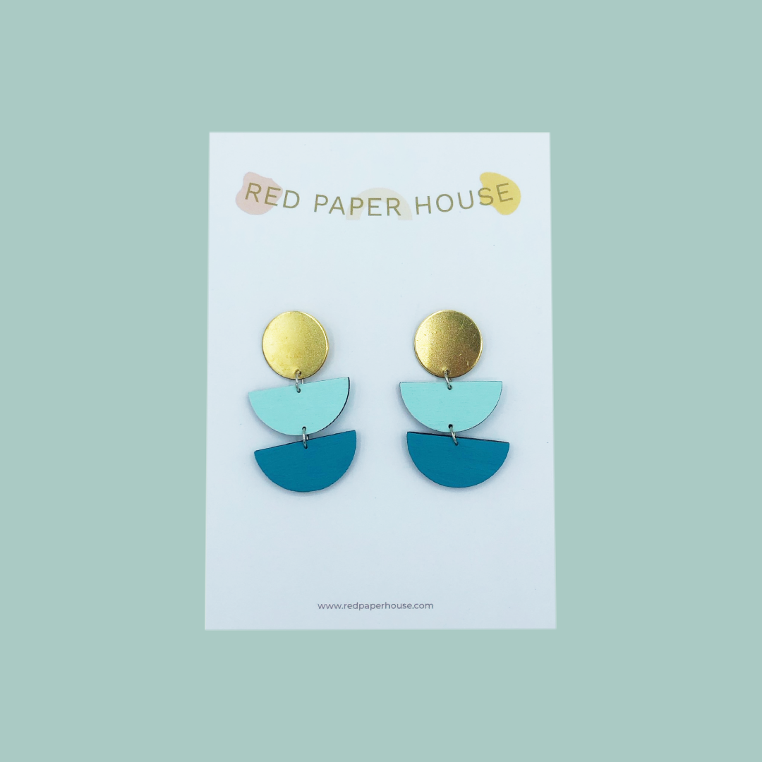 Pair of earrings on a Red Paper House branded card against a light green background