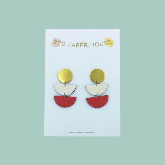 Colorful earrings on a Red Paper House branded card against a light green background