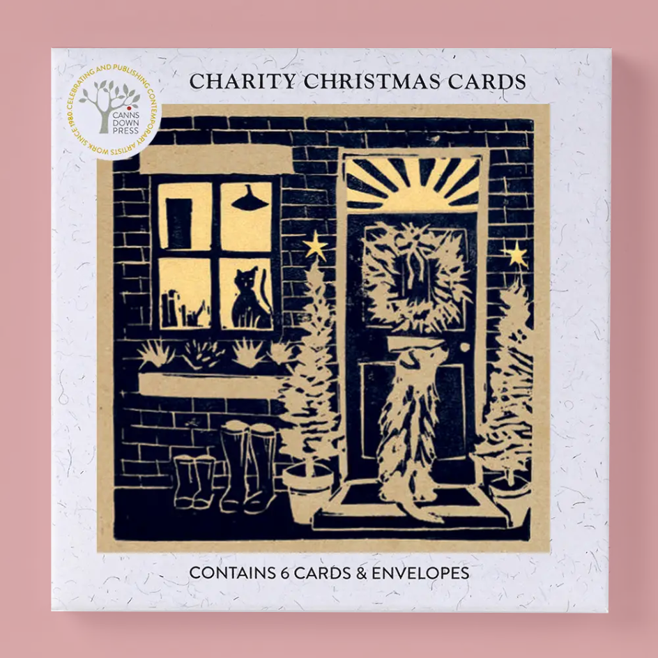 Charity Christmas Cards by Canns Down Press, featuring a square white card with a kraft borwn border and a black linocut illustration of a cozy front door, window with a cat silhouette, boots, and potted trees. Text on the card reads 'CHARITY CHRISTMAS CARDS' and 'CONTAINS 6 CARDS & ENVELOSES'.