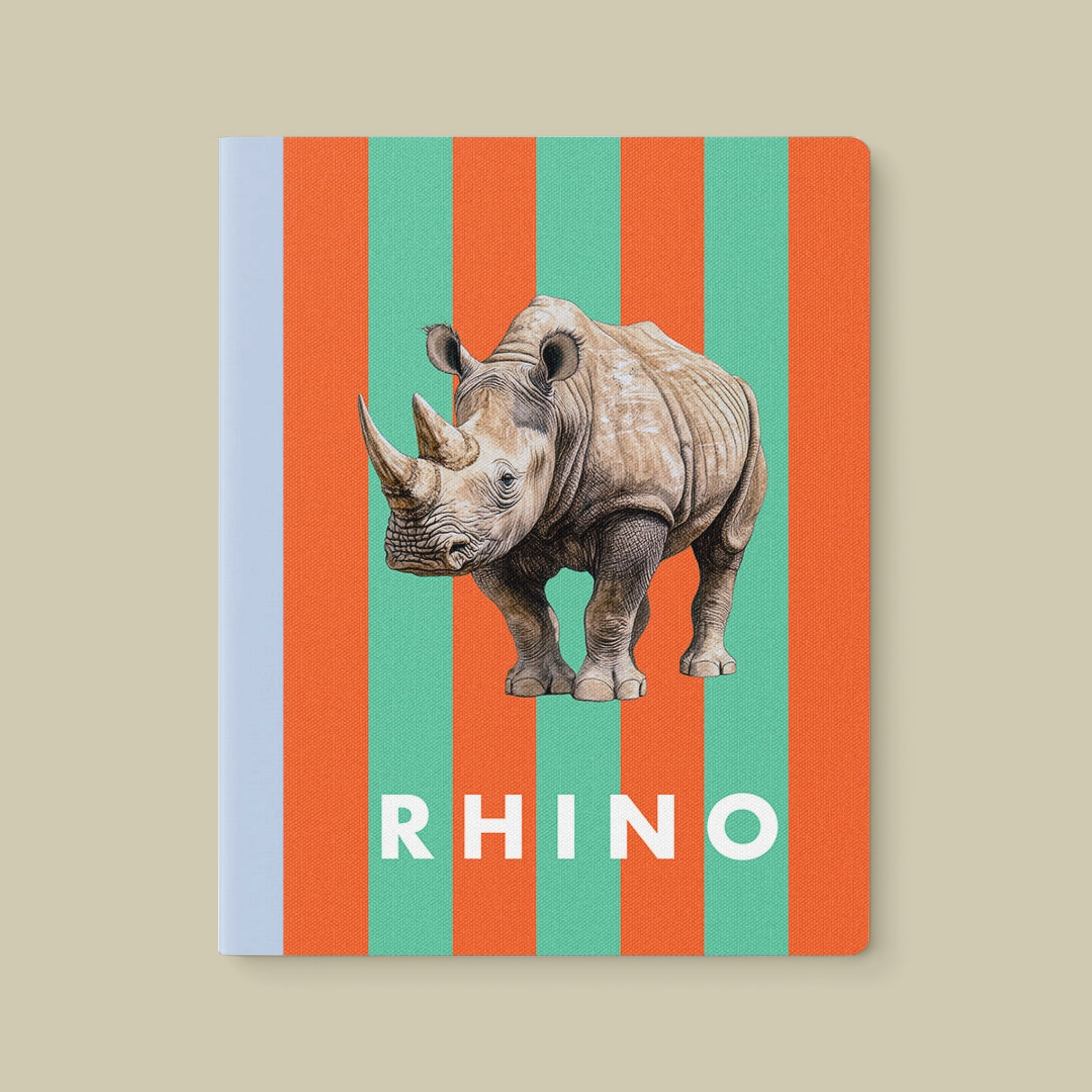 Notebook with vertical orange and green stripes, a blue spine, and a rhino illustration on the cover. The notebook is on a beige background.