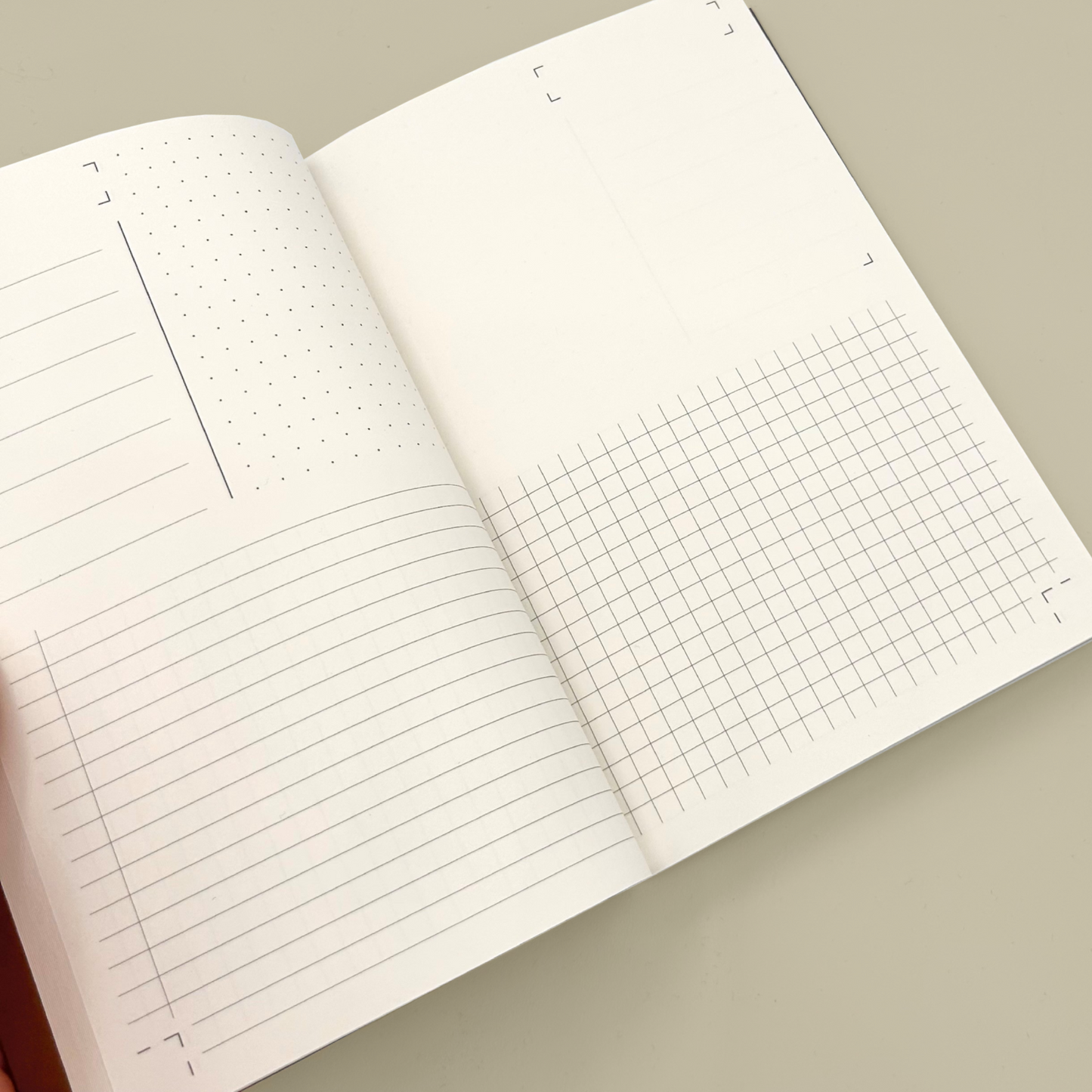 Open notebook with lined and grid pages on a beige background