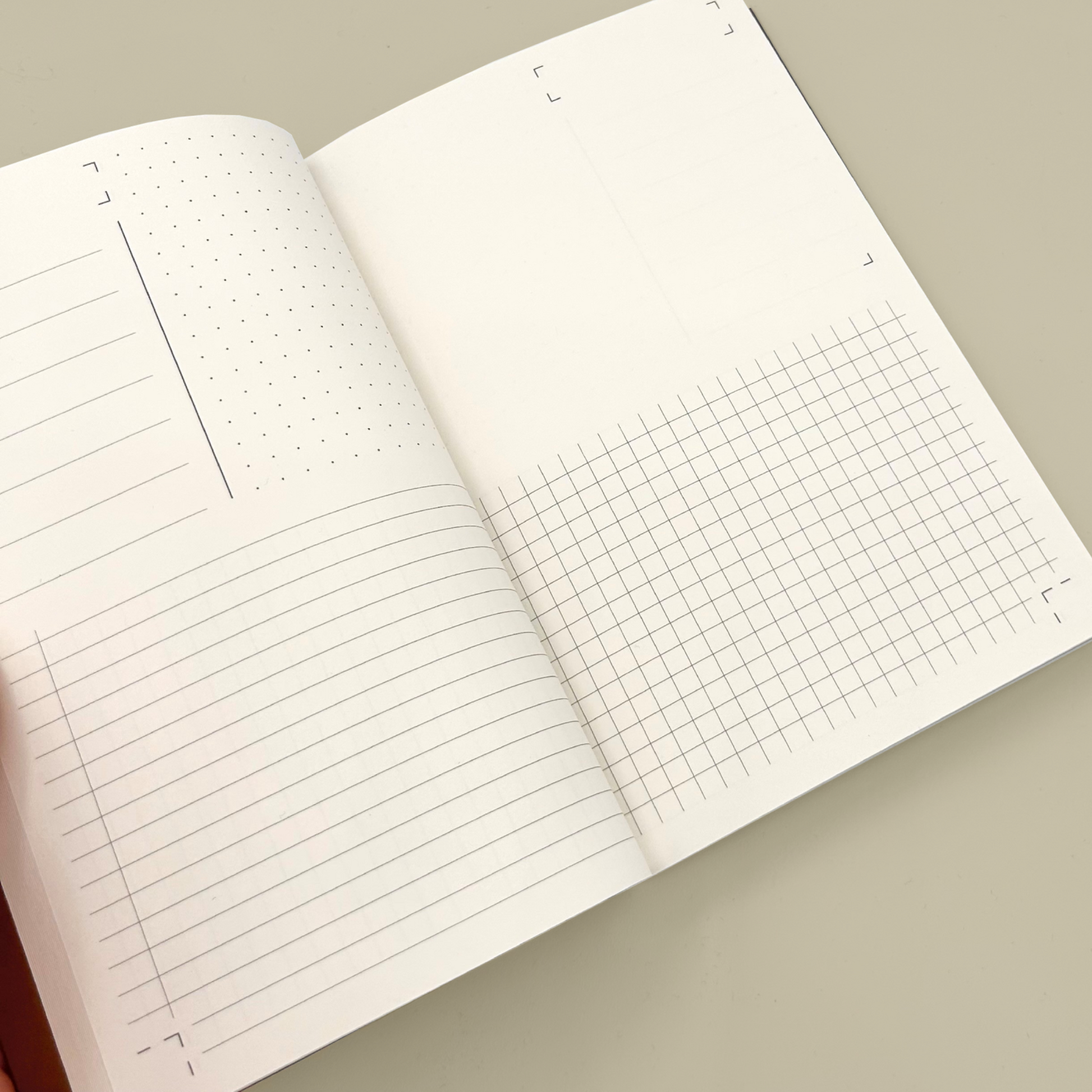 Open notebook with lined and grid pages on a beige background