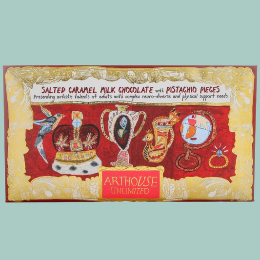 A rectangular chocolate bar package labeled 'Salted Caramel Milk Chocolate with Pistachio Pieces' by Arthouse Unlimited, featuring a red and gold illustrated design with whimsical objects on the front.