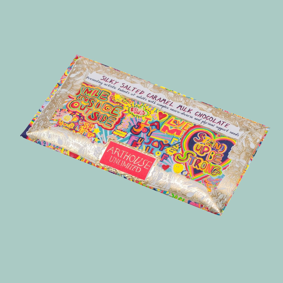 A single wrapped chocolate bar from Art House Unlimited, featuring a highly colorful, graffiti-style illustrated wrapper on a solid light blue-green background.