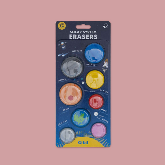Orbit Solar System Erasers toy set in its original packaging, featuring eight colourful erasers representing the planets of the solar system on a dark blue backing card against a solid pink background.