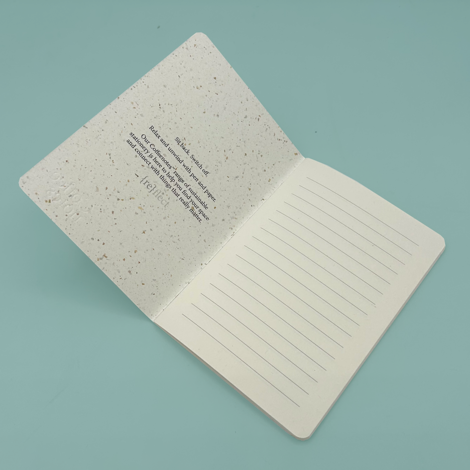 An open notebook with lined pages on one side and a printed quote on the other, set against a solid light blue background.