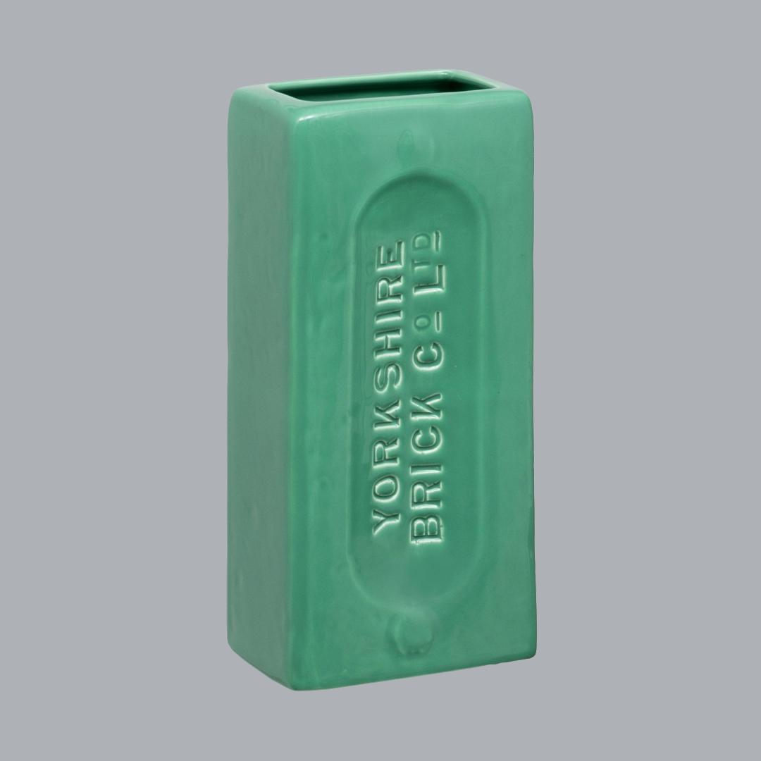 A green ceramic brick-shaped vase with 'YORKSHIRE BRICK Co Ltd' embossed on the side.