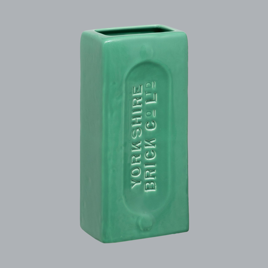 A green ceramic brick-shaped vase with 'YORKSHIRE BRICK Co Ltd' embossed on the side.
