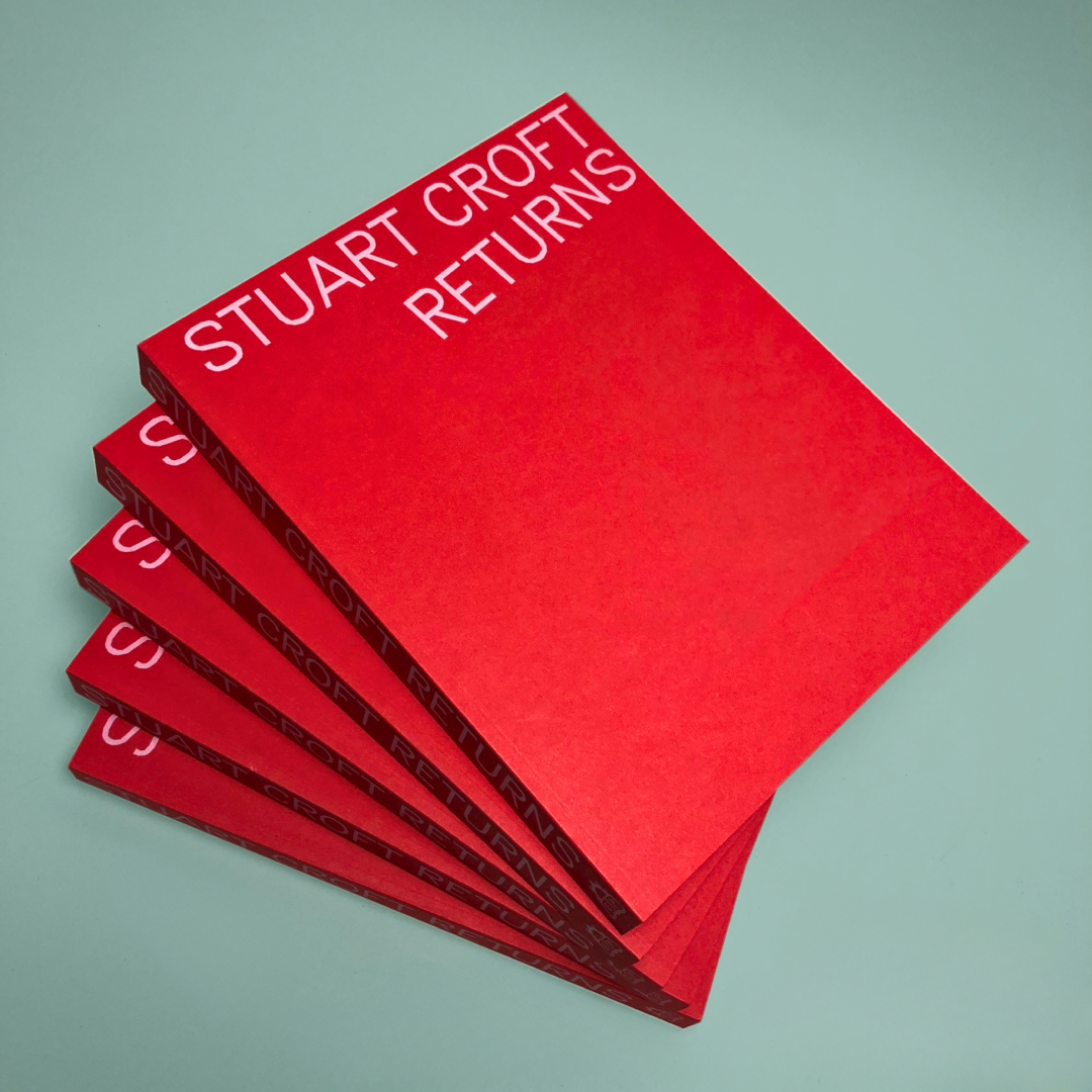A stack of red books with 'STUART CROFT RETURNS' in pink text on the cover.
