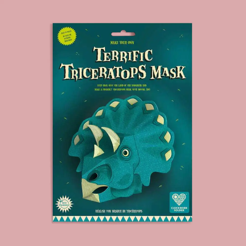 Packaged DIY Triceratops mask kit by Chocolate Cookie, featuring a dark teal cardboard backing with a large illustration of a green Triceratops and the text 'Terrific Triceratops Mask'.