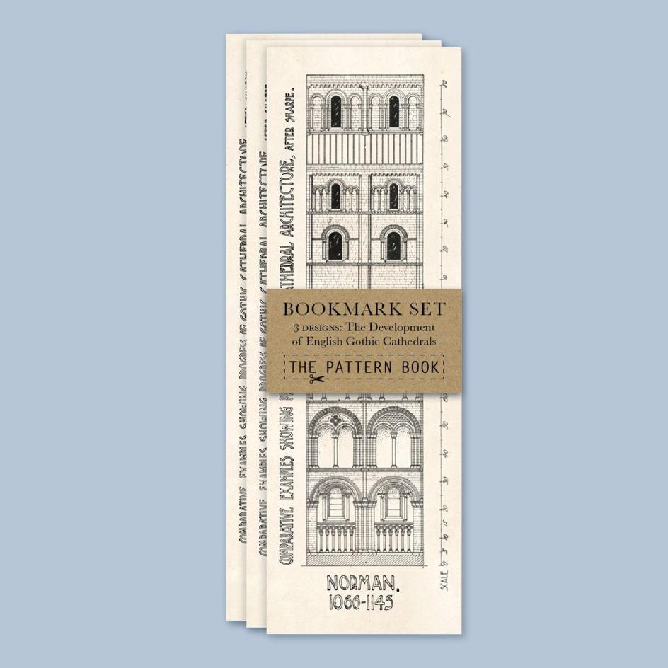A set of three vintage-style bookmarks fanned out against a solid light blue background. The bookmarks are cream-colored with black architectural line drawings of Norman Gothic cathedrals and a central tan belly band reading 'BOOKMARK SET' and 'THE PATTERN BOOK'.