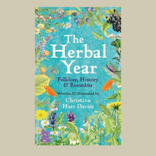 Book cover of 'The Herbal Year' with floral design on a blue background