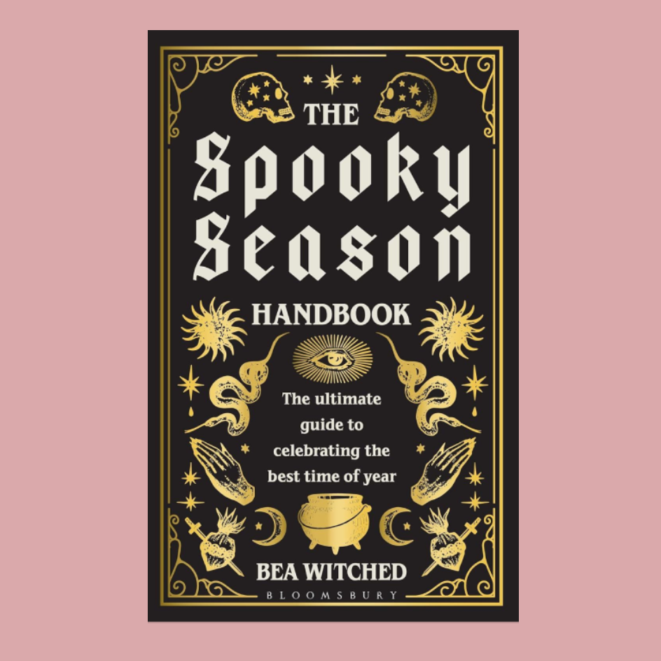 The Spooky Season Handbook book cover by Bea Wicked, featuring a black background with ornate gold illustrations and white gothic text, centered on a dusty pink background.