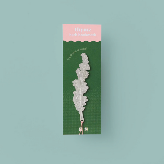 Silver coloured bookmark in the shape of a thyme leaf, in a pink and green packet. 
