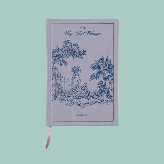 Notebook titled 'The Very Tired Woman' with a decorative cover on a light blue background