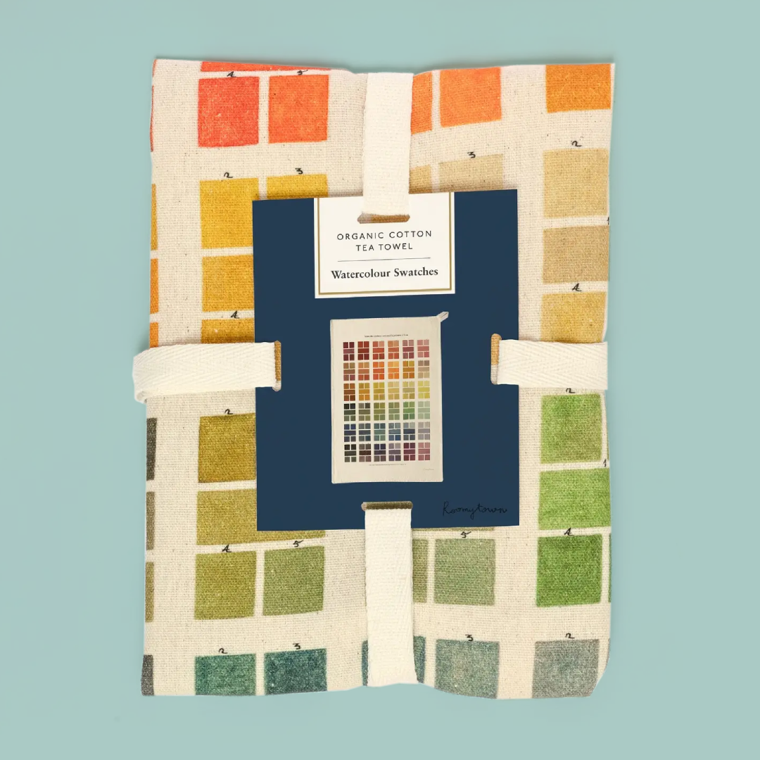 Tea towel with colorful pattern and brand label on a teal background