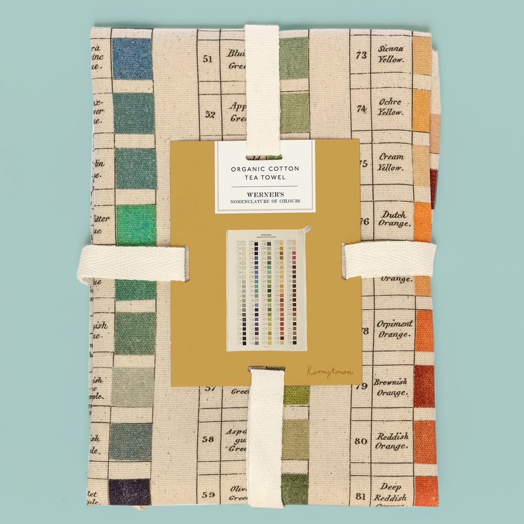 Packaged organic cotton towel with colour swatches on a teal background