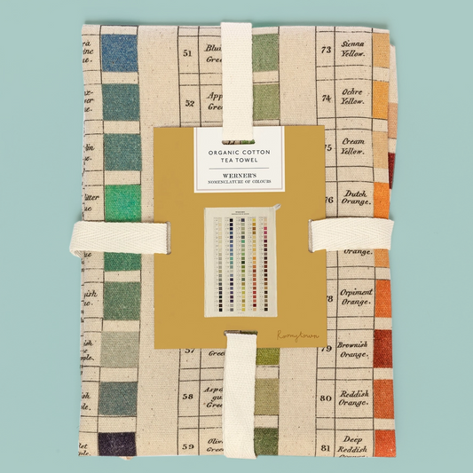 Packaged organic cotton towel with colour swatches on a teal background