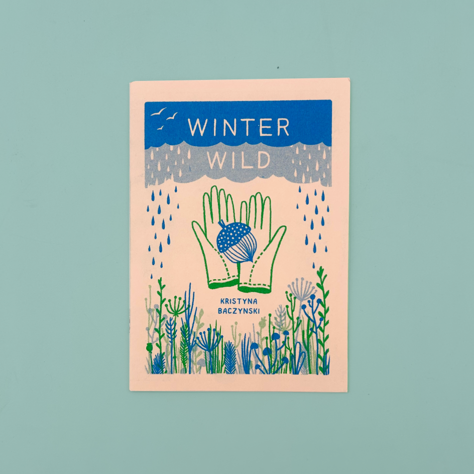 A book cover titled 'WINTER WILD' by Kristyna Baczynski, featuring a stylized illustration of green hands holding a blue and white acorn, surrounded by blue and green wildflowers on a pale peach background, set against a solid light teal backdrop.