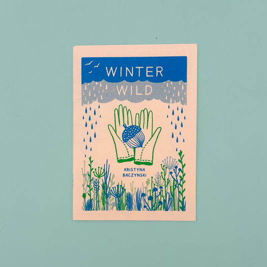 A book cover titled 'WINTER WILD' by Kristyna Baczynski, featuring a stylized illustration of green hands holding a blue and white acorn, surrounded by blue and green wildflowers on a pale peach background, set against a solid light teal backdrop.