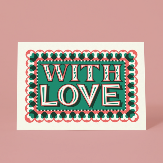 A  greeting card with a retro-style graphic design that reads 'WITH LOVE' in bold white letters with red and dark green outlines, set against a teal background. The card is framed by a scalloped border of red and dark green hearts, and it is photographed on a solid dusty pink background.