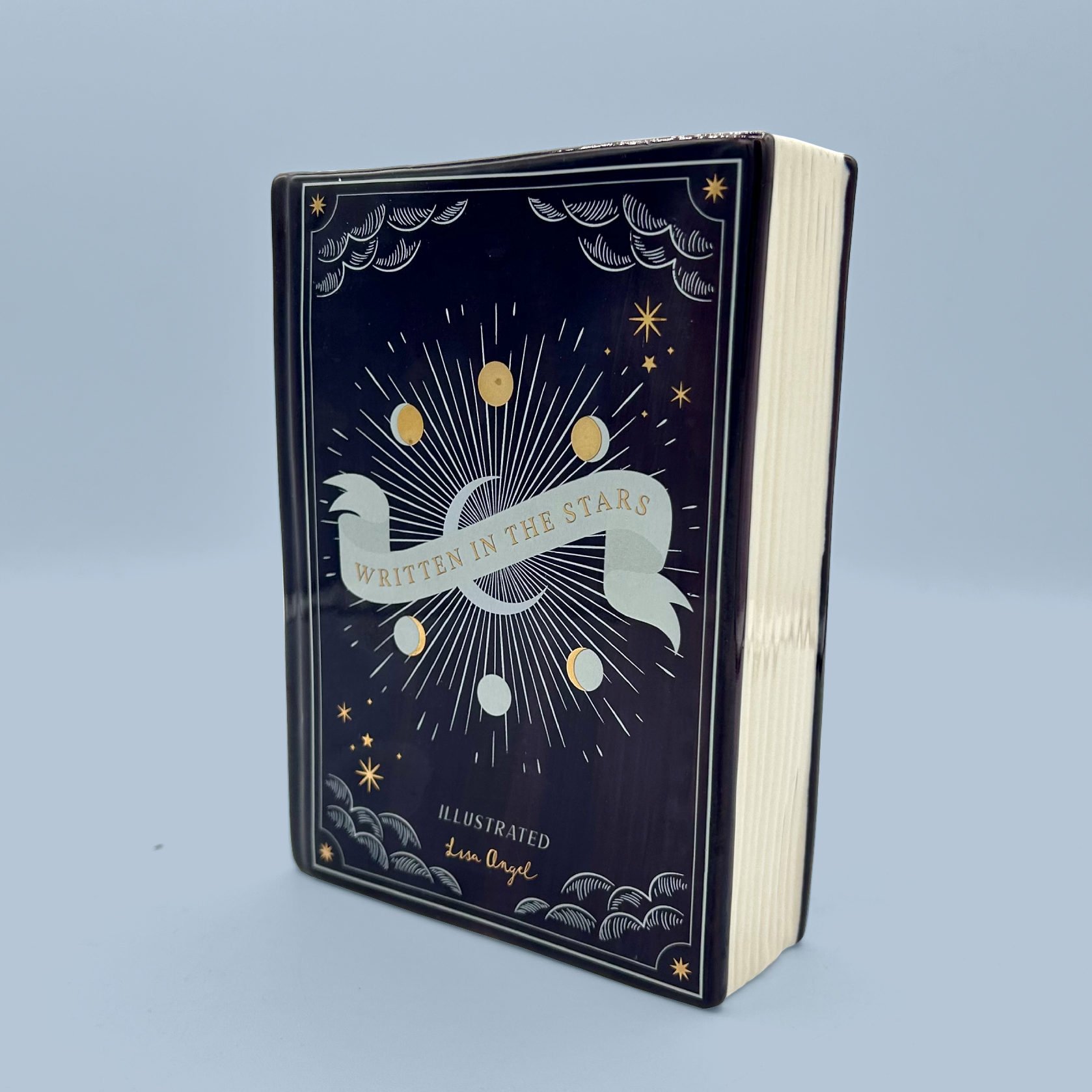 Book shaped vase titled 'Written in the Stars' with celestial design on a light blue background